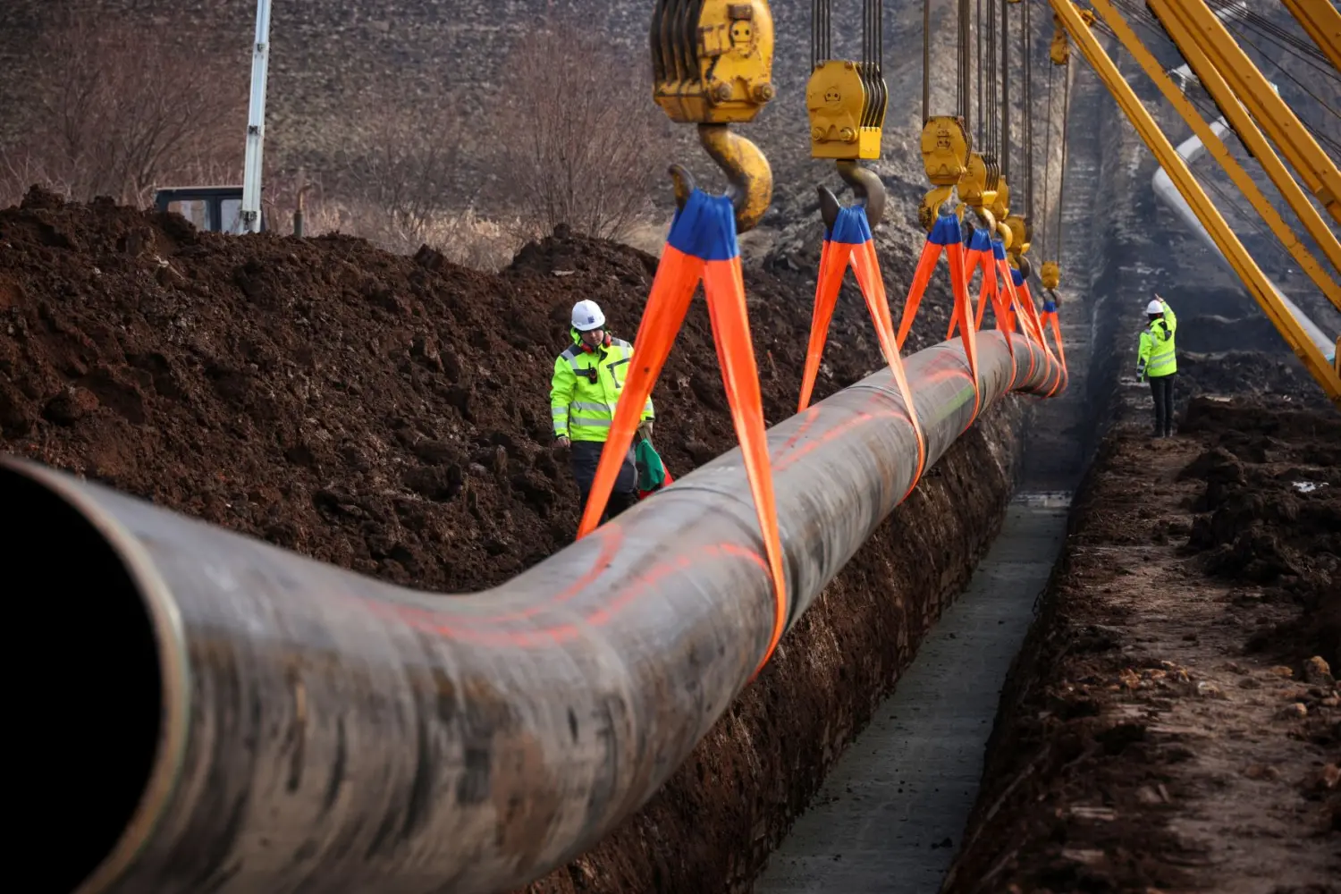 Workers stand next to a pipe at the launch of the construction of an interconnector gas pipeline to link the gas networks of Bulgaria and Serbia, near Golyanovtsi, Bulgaria, February 1, 2023.